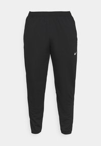 Zwarte Nike joggingsbroek met een elastische tailleband, taps toelopend broekdesign en een subtiele witte logo-accent op de linker dij. Glad textuur van de stof.