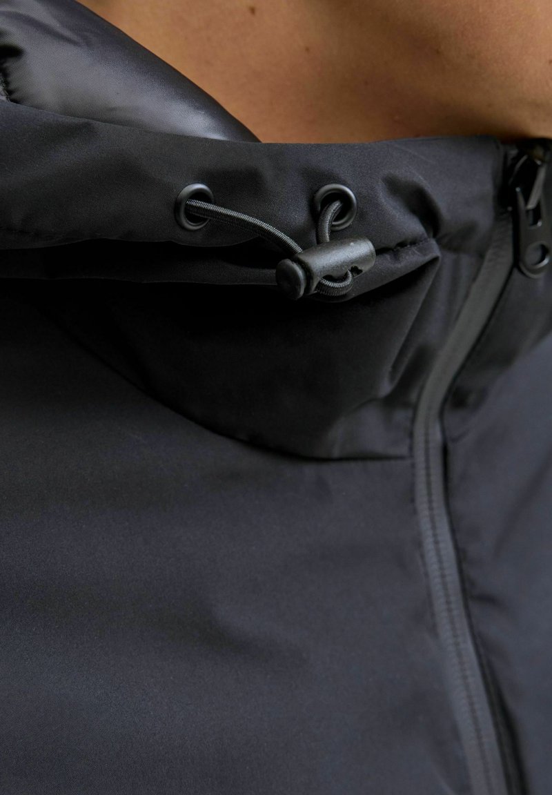 Zwarte hooded jacket met een gladde, waterafstotende buitenkant, verstelbare trekkoordsluiting en een volle lengte rits aan de voorkant.