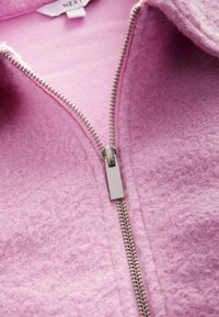 Pehmeast roosast fleece'i kapuutsiga jope, millel on tekstureeritud viimistlus, hõbedane vetthülgav tõmblukk ja näha olev sisemine vooder kaeluses.