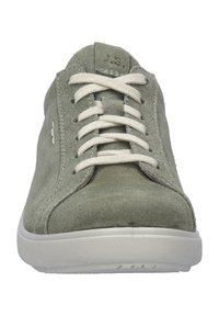 Sneakers en daim vert avec lacets beiges, bout rond et détails de couture subtils. La semelle en caoutchouc est légèrement texturée pour une meilleure adhérence.