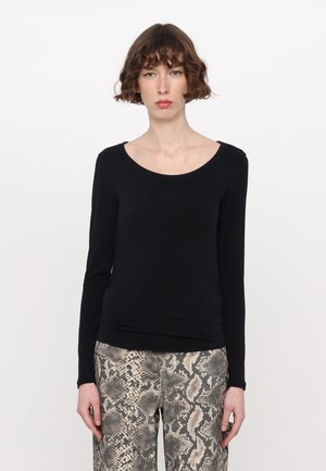 Zwarte, langmouw top met een brede halslijn, heeft een getailleerde pasvorm en een gladde textuur, gecombineerd met beige en zwarte slangenprint broek.