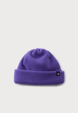 Gorro de lana polar morado con borde doblado y un pequeño parche de logo negro en un lado sobre un fondo blanco liso.