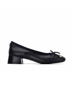 Zapato de mujer negro con tacón bajo, con patrón texturizado de piel de serpiente y pequeño lazo en la puntera redondeada, mostrado de lado sobre fondo blanco.