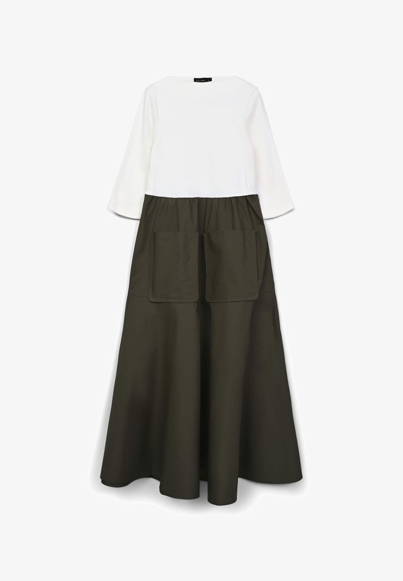Abito lungo con parte superiore bianca e gonna verde oliva. La gonna presenta due grandi tasche frontali e una vita arricciata.