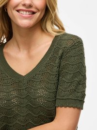 Olivgrüner gestrickter Oberteil mit V-Ausschnitt, kurzen Ärmeln und Wellenmuster-Textur. Ein gewellter Saum an den Ärmeln fügt Details hinzu.