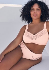 Sæt med ferskenfarvet bh med blondekant og matchende trusser. Glat stof med blomsterblonde og brede stropper for støtte.