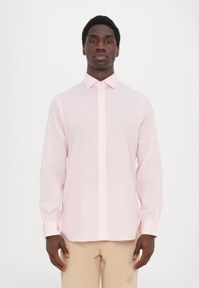 Camisa de botones de color rosa claro con rayas verticales, mangas largas y cuello. Presenta un pequeño emblema de logo en el pecho y detalles de botones.
