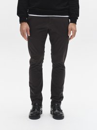 Dunkelbraune, schlanke Hose aus leichtem Stoff mit glatter Textur und Seitentaschen, kombiniert mit schwarzen Schnürschuhen.