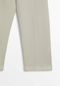 Beige denim broek met rechte pijpen, voorzien van subtiele stikdetails langs de zijkanten en een schone, effen zoom.