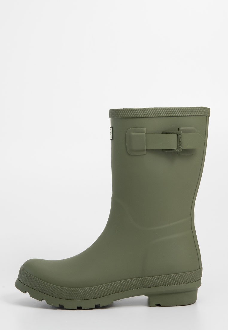 Bota de lluvia verde de goma con suela texturizada, acabado liso, correa lateral ajustable y diseño de punta redondeada. Altura hasta la mitad de la pantorrilla.
