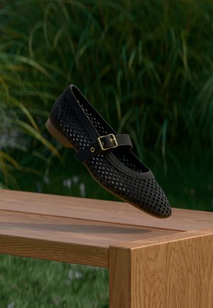 Zwarte geperforeerde balletpump met een puntige neus, een dunne band met een gouden gesp en een lage, gladde zool.