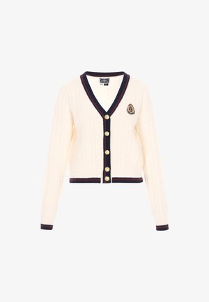 Cardigan en maille torsadée crème avec un col en V, des bordures côtelées bleu marine, des boutons dorés et un emblème sur la poitrine gauche. Design court.