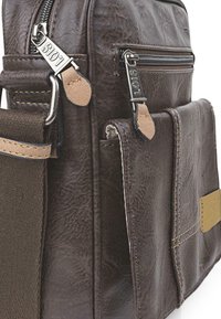 Bolso de hombro de cuero sintético marrón con herrajes plateados, dobles cremalleras y acentos en color beige; incluye un bolsillo frontal y una correa ajustable.