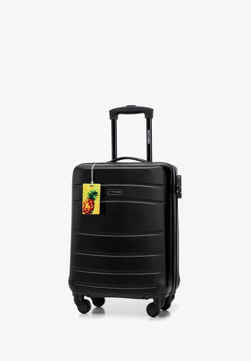 Zwarte hard-shell koffer met een gestructureerd oppervlak, uitschuifbare handgreep, vier wielen en een ananas-thema bagagetag bevestigd.