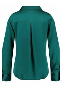 Blusa di satin verde smeraldo, maniche lunghe con polsini bottonati, colletto classico, dettagli a pieghe sul retro, texture liscia e design su misura.