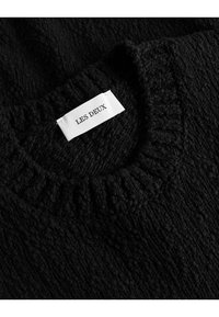 Czarny sweter z teksturowanej dzianiny z ryżowym okrągłym dekoltem. Posiada białą metkę z napisem "LES DEUX" wyszytym na czarno. Miękki, gruby materiał.