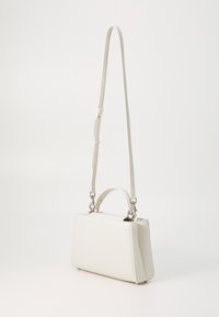 Sac à bandoulière en cuir blanc avec une sangle détachable, forme rectangulaire, devant plat et accent en métal argenté. Texture lisse.