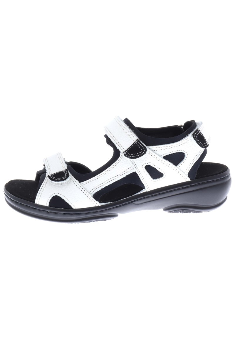 White leather sandal with black accents, adjustable hook-and-loop straps, open design, cushioned footbed, and a durable black sole.