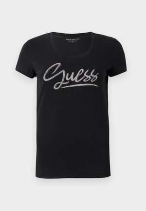 T-shirt nera da donna a maniche corte con scollo rotondo e logo "Guess" decorato con piccole borchie argentate sul petto.
