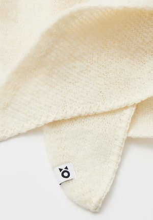 Sciarpa lavorata a maglia di colore crema con una texture morbida, caratterizzata da un bordo a onde e un'etichetta tessuta con un piccolo logo.