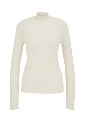 Ilgas rankovėmis, aukštu kaklu megztinis kreminės spalvos, pasižymintis tekstūruotu medaus korių raštu ir šiek tiek plonintais rankovių kraštais. Pagamintas iš lengvos medžiagos.