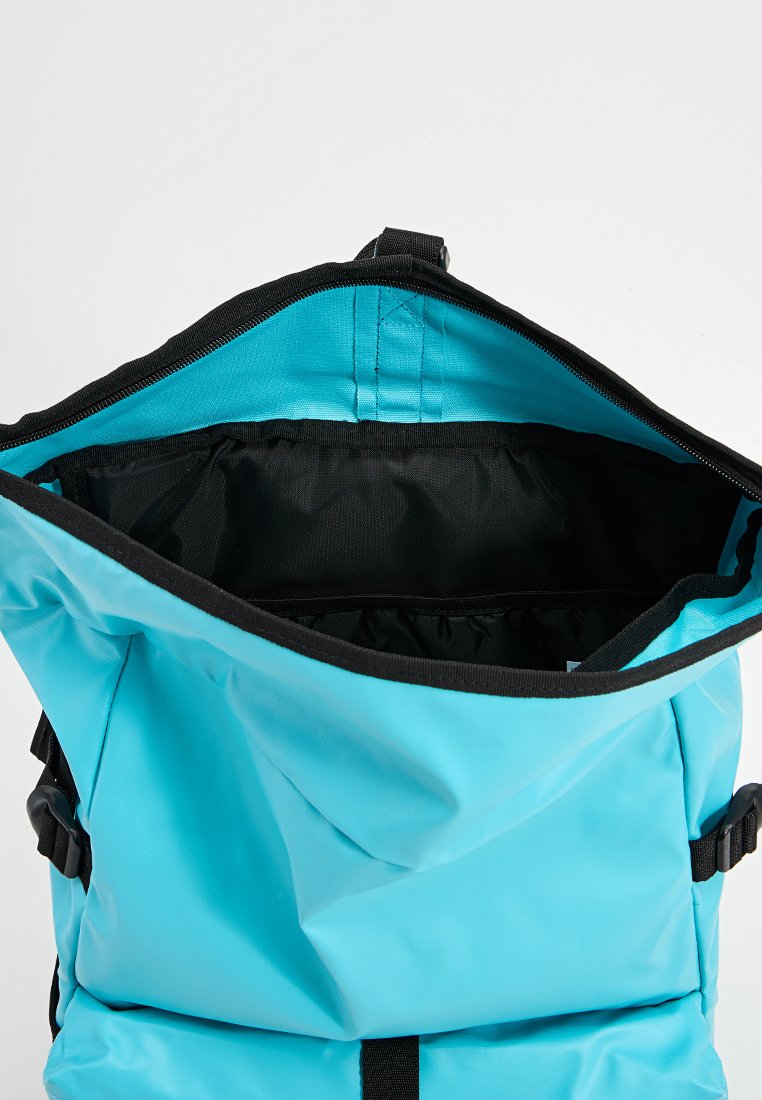 Blauer wasserdichter Rucksack mit einem Rollverschluss. Verfügt über schwarze Akzente, verstellbare Träger und ein geräumiges schwarzes Innenfutter.