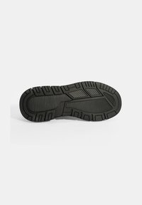 Semelle de chaussure noire avec un motif de grip texturé, présentant des crampons profonds et des nervures horizontales pour une meilleure traction et durabilité.