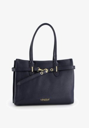 Sac fourre-tout en cuir marine avec un design structuré, double poignée supérieure, accents dorés et une sangle amovible. Présente un logo en relief à la base.