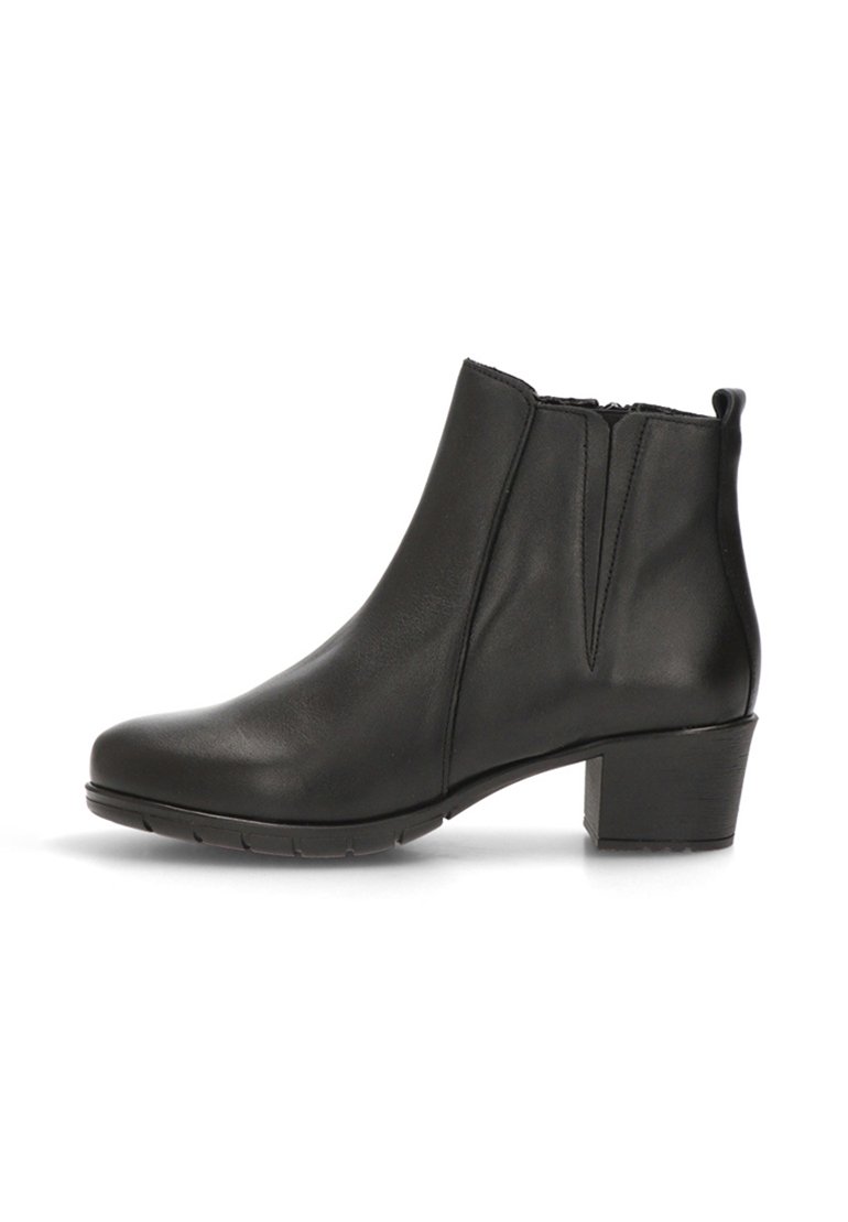 Bota de tobillo de cuero negro con punta redonda, costura mínima, gomas laterales y un tacón grueso. La suela de goma proporciona tracción.