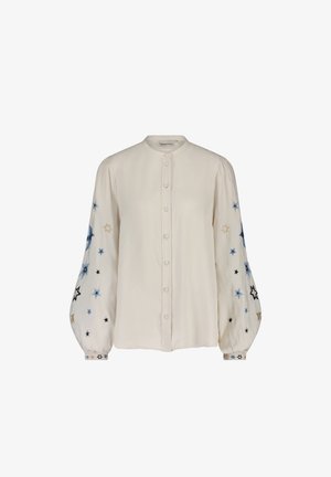 Knopenblouse van crèmekleurige stof, met ballonmouwen en borduursel van blauwe, zwarte en gouden sterren. Zachte textuur met een ronde kraag.