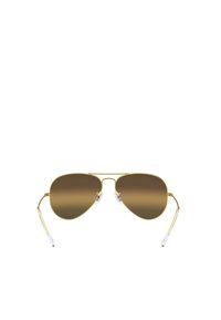 Occhiali da sole aviator in oro con lenti a gradiente marrone. Caratteristiche includono una sottile montatura in metallo, cuscinetti nasali trasparenti e stanghette slanciate con punte bianche.