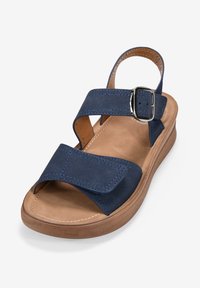 Navy blue sandal with two wide fabric straps and a buckle detail. Contoured tan insole and a textured tan platform.