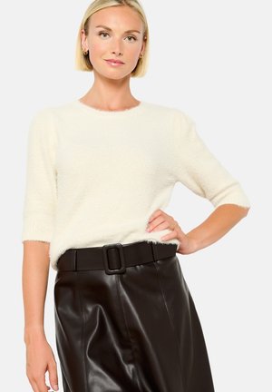 Cream, fuzzy knit sweater with short sleeves, round neckline, paired with a black leather skirt featuring a wide belt and square buckle.