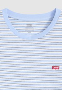 Light blue striped T-shirt with navy and white horizontal lines. Features a round neckline and a small red Levi's logo on the chest.