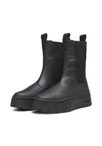 Mustat nahkaiset nilkkurit, joissa on joustavat sivupaneelit, paksut pohjat ja vetoketjut helppoa pukemista varten. Suorapintainen rakenne minimalistisilla yksityiskohdilla.