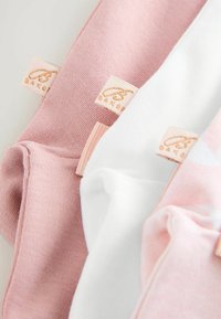 Tre paia di calze in rosa pastello, rosa chiaro e bianco. Ognuna presenta un piccolo etichetta tessuta con la scritta "BAKER" in lettere dorate. Tessuto morbido e texture.