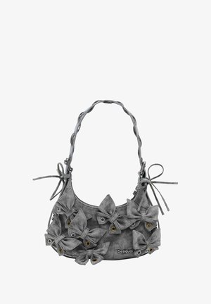 Grijze suède handtas met een ronde vorm, versierd met meerdere stoffen strikken en messing ogen, met een gevlochten band en verstelbare koorden.