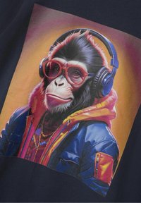 Camiseta gráfica con una ilustración digital de un mono con gafas rojas y auriculares, vestido con una chaqueta azul y naranja sobre un fondo oscuro.