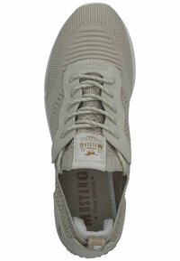 Sneaker beige chiaro con tomaia in rete, lacci piatti e etichetta logo sulla linguetta. Superficie testurizzata e suola ammortizzata visibile.