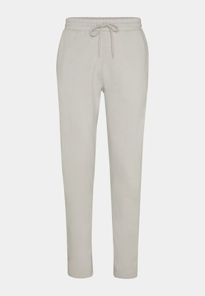 Pantaloni di tuta in cotone grigio chiaro con elastico in vita, gambe affusolate e polsini a costine. Tessuto liscio, design semplice, senza motivi o dettagli.