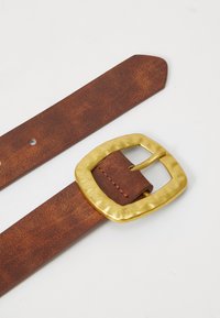 Brown leather belt with a textured finish, featuring a hammered gold square buckle and several attachment holes for sizing adjustment.