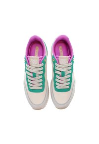 Paire de baskets écrues avec des accents verts, des lacets beige, une doublure intérieure violette et une étiquette "Since 1890" sur la languette, vue de dessus.