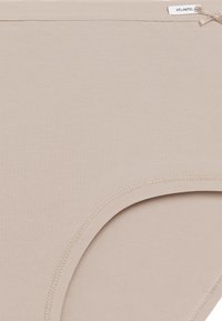 Beżowe bawełniane majtki o gładkiej fakturze, z elastycznym paskiem w talii i przeszytymi krawędziami dla trwałości. Metka przymocowana u góry.