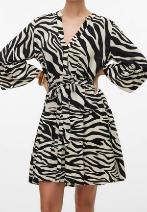 Zwart-witte jurk met zebraprint, V-hals, lange mouwen, een geraffineerde taille en een gestrikt ceintuur. Lichtgewicht stof met een flowy silhouet.