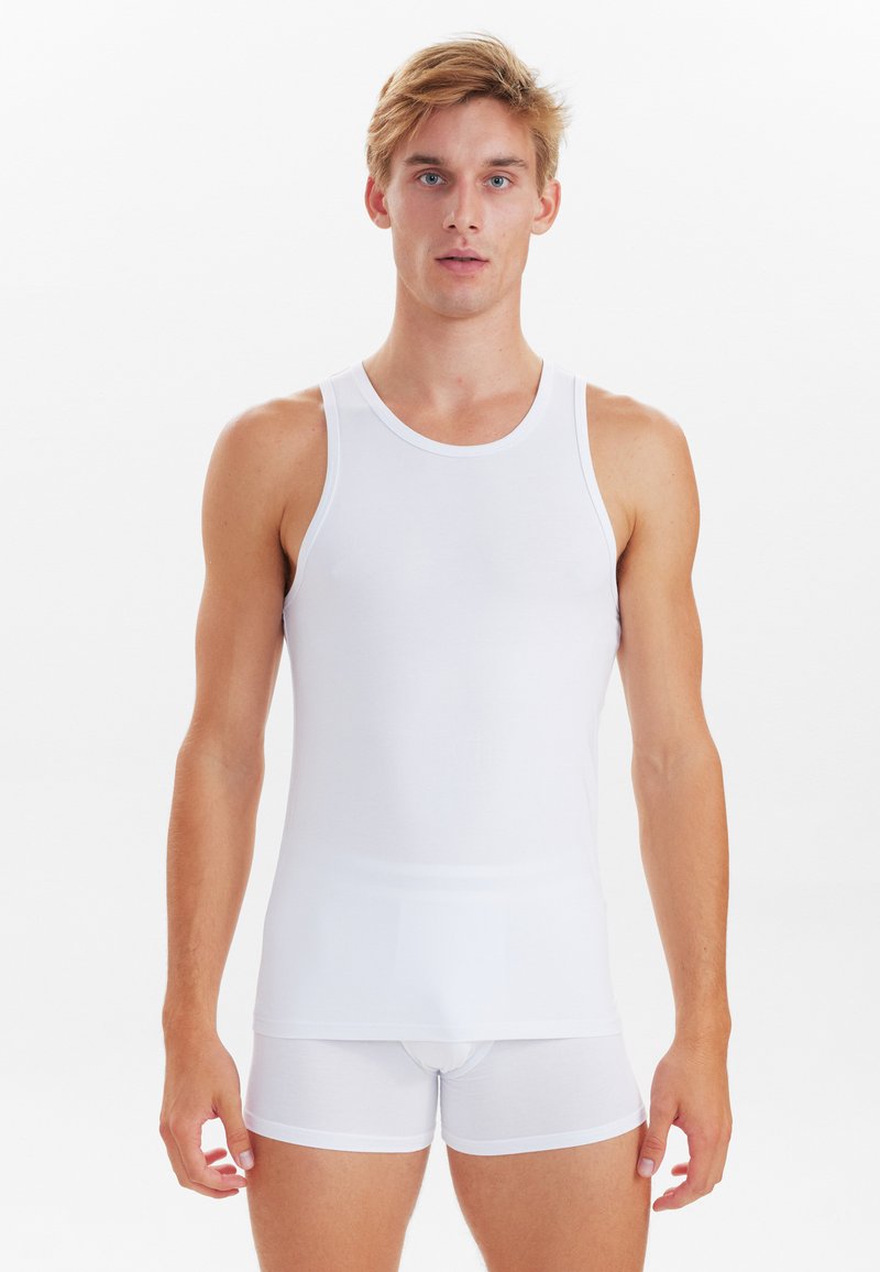 Hvid tanktop og shorts lavet af glat, letvægtsstof. Ærmeløs design med rund halsudskæring og tætsiddende silhuet.