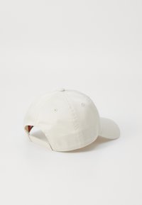 Hvid baseballkasket med en glat stofstruktur, seks-panel design og justerbar rem bagpå. Rund skygge, minimalistisk stil.