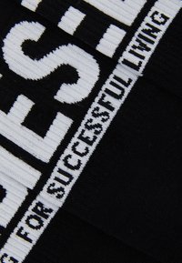 Tejido negro con texto en blanco en negrita. El diseño destaca la frase "PARA UNA VIDA EXITOSA" en un patrón a rayas, con un acabado texturizado.