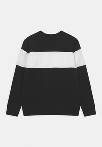 Svart sweatshirt med en bred horisontell vit rand över mitten. Tillverkad av bomull med en mjuk textur och ribbade ärmslut.