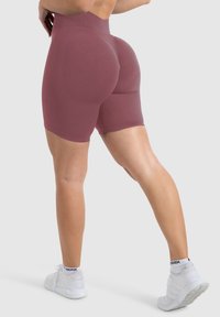 Hoge taille, bordeaux kleur sportshorts met een gladde textuur, een aansluitend ontwerp en een lengte tot halverwege de dijen, gecombineerd met witte sportieve schoenen.