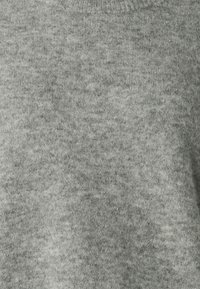 Pull gris en maille avec un col rond, présentant une surface texturée avec un aspect doux et duveteux. Aucun motif ou embellissement visible.